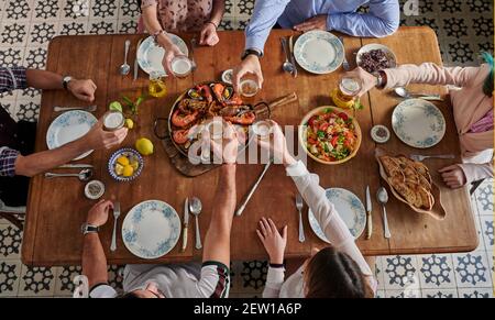 Du dessus de la récolte groupe d'amis méconnaissables se rassemblant à Table avec plats variés dans le restaurant espagnol et verres à vin avec des boissons pendant Banque D'Images