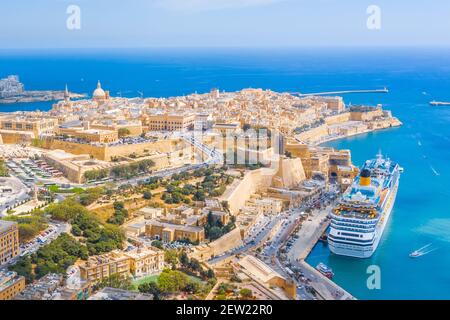 Vue aérienne de l'église de la Dame du Mont Carmel, de la cathédrale Saint-Paul et d'une grande baie avec un navire de croisière dans la ville de la Valette, Malte Banque D'Images