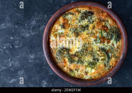 Bol en céramique avec frittata de légumes, simple nourriture végétarienne. Frittata avec oeuf, poivre, oignon, brocoli et fromage sur table en bois, gros plan. Italien Banque D'Images