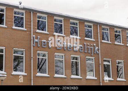 ZUTPHEN, PAYS-BAS - 10 février 2021 : façade extérieure de l'école secondaire locale avec lettres du nom couvertes de neige. TRADUCTION : 'UNICIPAL' Banque D'Images