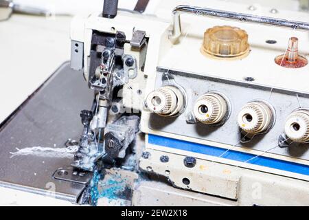 Serrure de machine à coudre industrielle à quatre fils. Un overlock est un type de couture qui se déforme le long du bord d'un ou deux morceaux de tissu pour la bordure. Banque D'Images