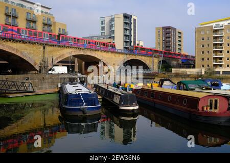 LONDRES - 2 MARS 2021 : le bassin de Limehouse à Limehouse. Un train Dockland Light Railway passe en arrière-plan. Banque D'Images