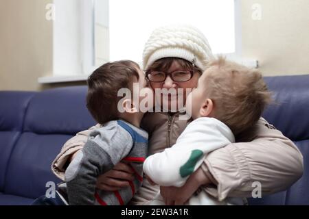 Petits-fils embrassant leur grand-mère sur le canapé Banque D'Images
