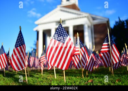 De nombreux drapeaux américains miniatures sont fixés sur l'herbe à l'avant d'une chapelle commémorative à un angle bas avec chapelle dans le fond Banque D'Images
