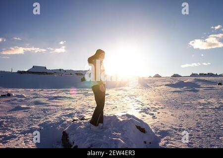 Femme randonnée dans les montagnes dans la neige. Réussir à atteindre le sommet. Des émotions heureuses. Banque D'Images