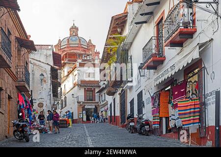 L'ancien centre colonial de Taxco, une petite rue avec des bâtiments coloniaux blancs et rouges et des boutiques de souvenirs, avec une église, le Templo de Santa Prisca, Banque D'Images