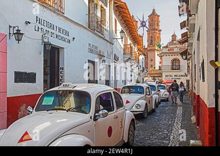 Taxis White Volkswagen Beetle dans une rue étroite dans le centre-ville colonial de Taxco de Alarcón, Guerrero, Mexique Banque D'Images