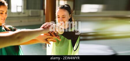 Bannière - format long, les jeunes gens de sport mettant leurs mains ensemble. Pile de mains. Unité et travail d'équipe. Les femmes sont heureuses Banque D'Images