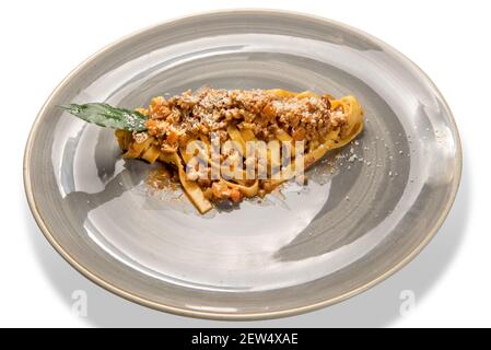 Tagliatelle al ragù bolognaise et parmesan râpé. Pâtes aux œufs avec sauce bolognaise à la viande dans un plat rustique isolé sur le blanc Banque D'Images