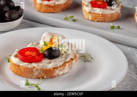 Bruschetta à la tomate, aux olives et à l'œuf de caille poché Banque D'Images