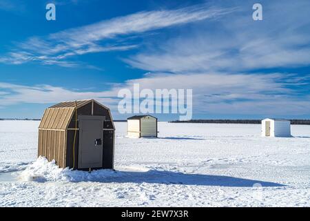 Pêche sur glace dans un port gelé le long de la côte de l'Île-du-Prince-Édouard, Canada. Banque D'Images