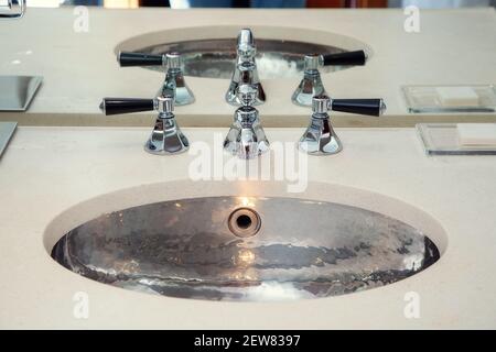 Lavabo en métal chromé avec mélangeurs dans la salle de bains Banque D'Images