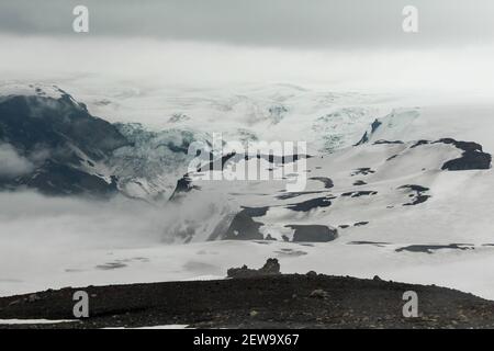 Paysage blanc enneigé et brumeux sur le sentier de randonnée de Fimmvorduhal, un glacier en arrière-plan, l'Islande Banque D'Images