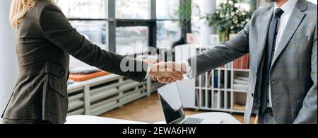 Photo panoramique d'une poignée de main de collègues hommes et femmes lors d'une réunion d'information. Les gens d'affaires prospères signent un contrat important, arrivant à un accord après les négociations Banque D'Images