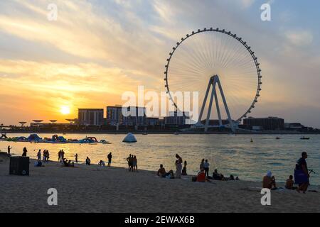 Touristes à JBR Marina Beach pendant le coucher du soleil et Ain Dubai Eye Ferris silhouette de roue. Les Émirats arabes Unis sont ouverts au tourisme avec des restrictions COVID. Banque D'Images