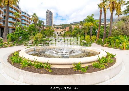 Les jardins paysagers, en pente et de l'eau Casino fontaine conçu par Adouard Andre, avec la ville derrière à Monte Carlo, Monaco. Banque D'Images