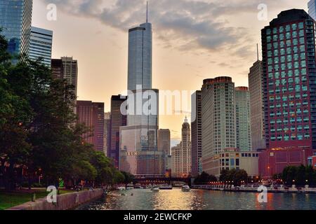 Chicago, Illinois, États-Unis. La lueur d'un soleil descendant s'attarde dans le ciel alors que le crépuscule commence à s'installer au-dessus de la Trump Tower et se reflète dans le fleuve Chicago. Banque D'Images