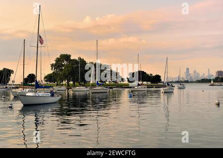 Chicago, Illinois, États-Unis. Les voiliers et les embarcations de plaisance se reposent dans le port de Montrose de Chicago peu après le lever du soleil le 4 juillet. Banque D'Images