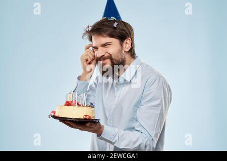 Un Homme Dans Une Chemise Avec Un Gateau Dans Son Mains Et Une Casquette De Fete Sur Sa Tete Photo Stock Alamy