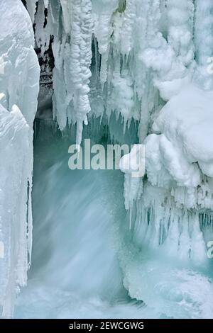 Une image verticale de l'Athabasca tombe en hiver avec des glaces glacées accrochées aux parois du canyon rocheux dans le parc national Jasper, en Alberta, au Canada. Banque D'Images