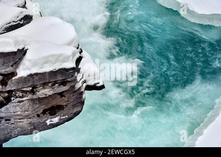 Une image horizontale de l'Athabasca tombe en hiver avec de la glace gelée accrochée aux parois du canyon rocheux dans le parc national Jasper, en Alberta, au Canada. Banque D'Images