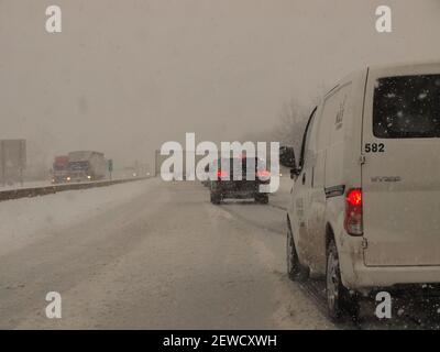 De gros neige et une remorque tracteur à châssis sur une autoroute Interstate américaine ont entraîné des retards importants. Banque D'Images