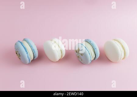 Macarons blancs et bleus sur la table, macarons sur fond rose. Photo de haute qualité Banque D'Images