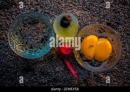 Masque de cheveux pour cheveux longs et sains composés de graines de cumin ou de zéera ou de jeera avec un peu de jaune d'œuf cru, de l'eau et un peu d'huile d'olive sur une couleur brune Banque D'Images