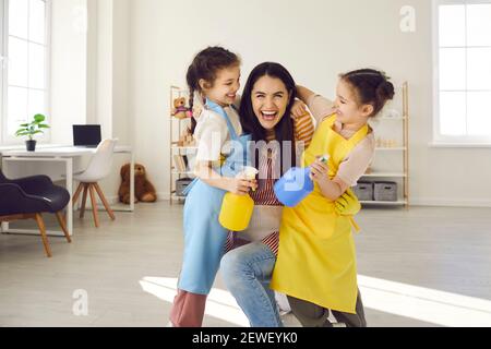 Mère avec deux filles s'amusant et se berner tout en nettoyant la maison. Banque D'Images