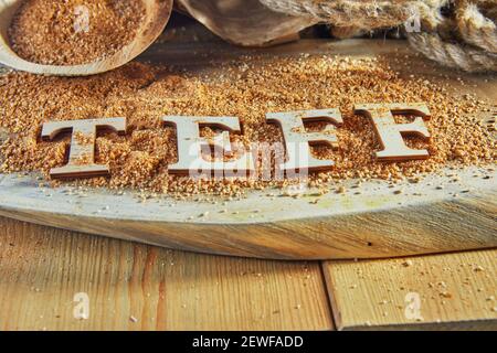 Teff, une alternative à l'ancien grain sans gluten avec le nom écrit en lettres de bois. Le téff est devenu un choix populaire pour une alimentation saine Banque D'Images