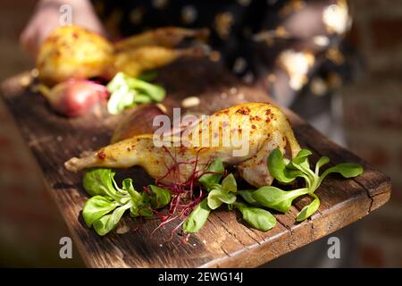 Faites cuire les aliments anonymes avec de la volaille appétissante avec des épices près du verger feuilles et pousses avec le pak choi sur la planche à découper Banque D'Images