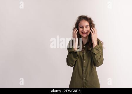 Une fille souriante et surprise tient ses mains près de son visage Banque D'Images