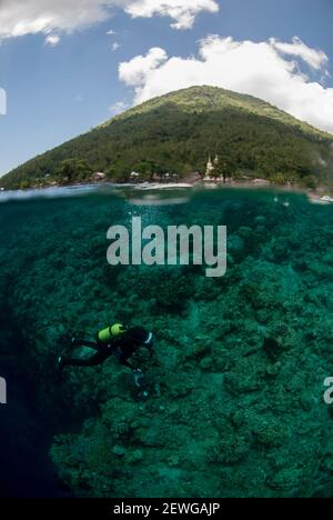 Plongeur avec caméra avec volcan Manado Tua en arrière-plan, site de plongée Bualo, Manado, Sulawesi, Indonésie Banque D'Images