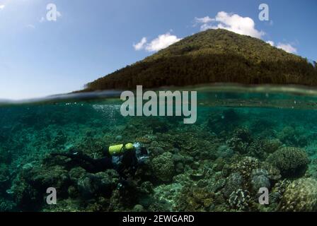 Plongeur avec caméra avec volcan Manado Tua en arrière-plan, site de plongée Bualo, Manado, Sulawesi, Indonésie,Asie Banque D'Images