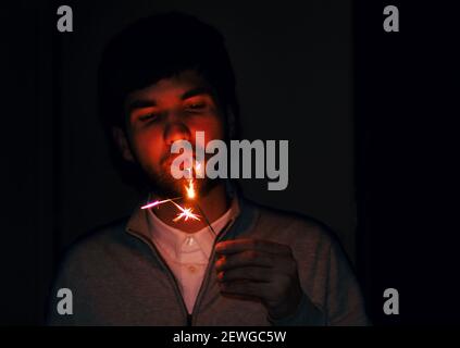 un jeune homme qui allume une cigarette Banque D'Images