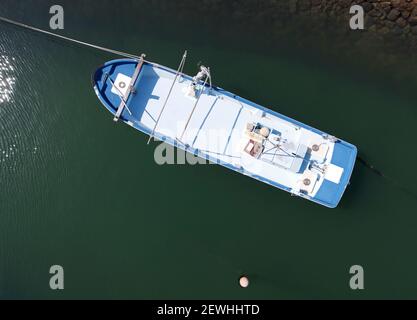 Vue aérienne du bateau de pêche amarré sur un fond de eau de mer vert profond Banque D'Images