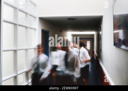 Un mouvement image floue d'un groupe d'élèves marchant dans le couloir d'une école secondaire complète, Angleterre, Royaume-Uni Banque D'Images