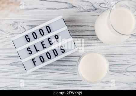 Lait malté de nuit pour un bon sommeil dans un pot et Verre à côté de l'inscription de bons aliments pour le sommeil Banque D'Images