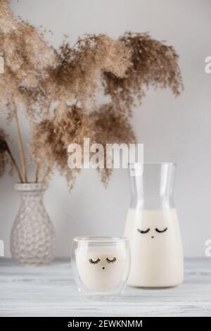 Lait malté de nuit pour un bon sommeil dans un pot et verre avec yeux fermés Banque D'Images