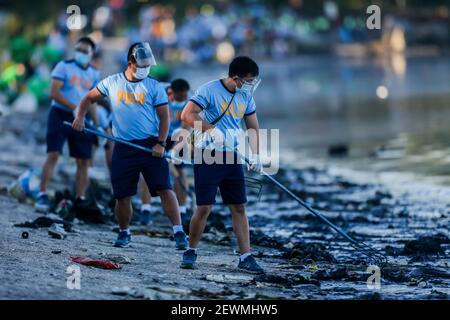 Ville de Las Pinas. 3 mars 2021. Les policiers de la police nationale des Philippines (PNP) collectent des ordures alors qu'ils se joignent à d'autres membres de divers organismes gouvernementaux et privés dans une activité de nettoyage côtier le long de la zone côtière de la baie de Manille, dans la ville de Las Pinas, aux Philippines, le 3 mars 2021. Le nettoyage des côtes a été organisé pour célébrer la Journée mondiale de la faune et de la flore et sensibiliser à la protection de la faune dans le monde entier. Crédit: Rouelle Umali/Xinhua/Alamy Live News Banque D'Images