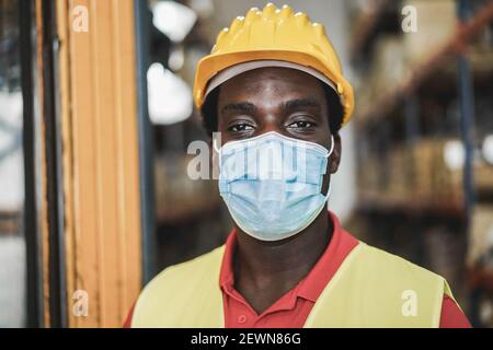 Portrait d'un ouvrier africain à l'intérieur de l'entrepôt tout en portant une protection Masque - attention aux yeux de l'homme Banque D'Images