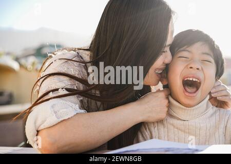 Bonne jeune mère asiatique ayant un moment tendre avec son enfant Plein air en été par beau temps - concentrez-vous sur le visage des enfants Banque D'Images