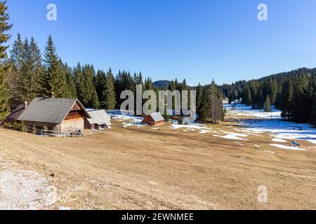 Forêt paysage d'hiver avec de petites maisons dans les Alpes slovènes. Banque D'Images