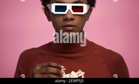 adolescent afro-américain en lunettes 3d contenant du pop-corn isolé rose Banque D'Images