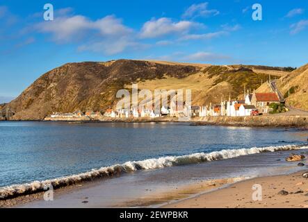 CROVIE VILLAGE ABERDEENSHIRE ECOSSE UNE RANGÉE DE MAISONS AVEC ROUGE TUILES DE TOIT ET UNE VAGUE SE BRISANT SUR UN PETIT SABLE PLAGE Banque D'Images