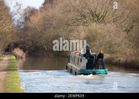 Un bateau à rames fait le chemin le long du canal de Coventry de Tamworth à Polesworth sous le soleil du printemps. Banque D'Images