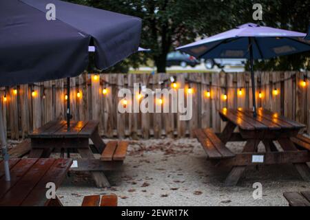 Tables de pique-nique parasols et lumières avec une clôture en bois à l'extérieur Pendant l'hiver en Géorgie Banque D'Images