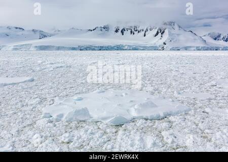 Montagnes enneigées et glace de mer dense dans le chenal Neumayer, l'archipel de Palmer, l'Antarctique, les régions polaires Banque D'Images