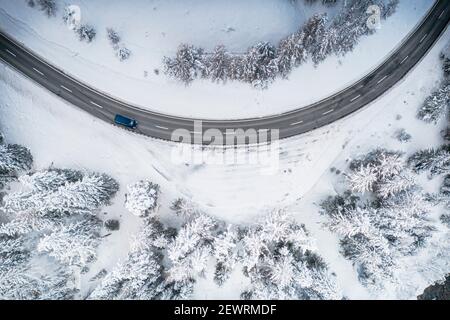 Voiture roulant dans les virages sur la route de montagne enneigée d'en haut, Suisse, Europe Banque D'Images