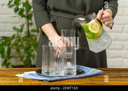 femme versant de l'eau infusée de fruits du verre jag au verre, boissons, régime, concept de détox Banque D'Images
